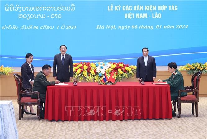 Thủ tướng Phạm Minh Chính và Thủ tướng Lào Sonexay Siphandone chứng kiến Lễ ký Nghị định thư hợp tác biên phòng giữa Bộ Quốc phòng Việt Nam và Bộ Quốc phòng Lào. Ảnh: Dương Giang/TTXVN.