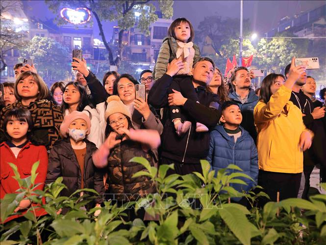 Người dân thích thú với màn bắn pháo hoa tại hồ Hoàn Kiếm đón năm mới Giáp Thìn. Ảnh: Hoàng Hiếu/TTXVN