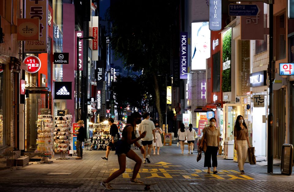 Người phụ nữ trượt ván trên phố mua sắm ở Seoul, Hàn Quốc hôm 12-7. Ảnh: Reuters