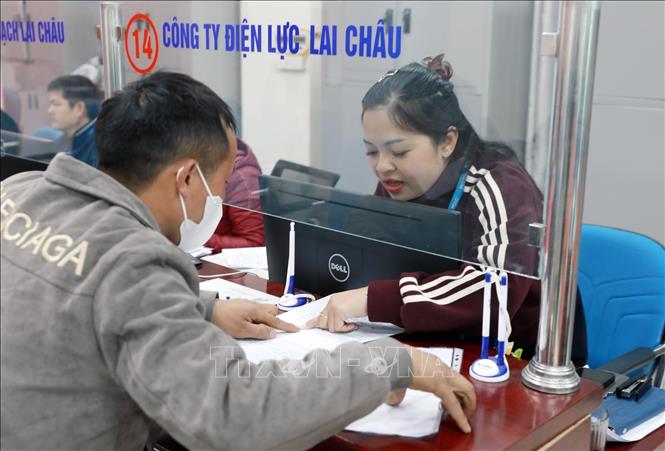 Hướng dẫn người dân làm thủ tục cấp điện sinh hoạt tại Trung tâm Phục vụ hành chính công tỉnh Lai Châu. Ảnh: Quý Trung/TTXVN