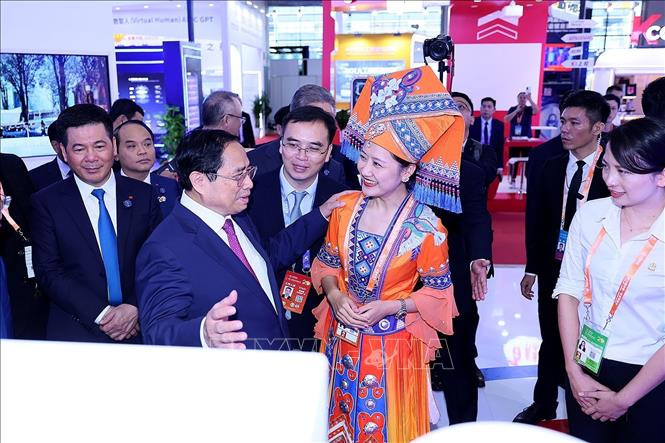 Thủ tướng Phạm Minh Chính đến tham quan khu gian hàng thương mại của Việt Nam và Trung Quốc. Ảnh: Dương Giang/TTXVN