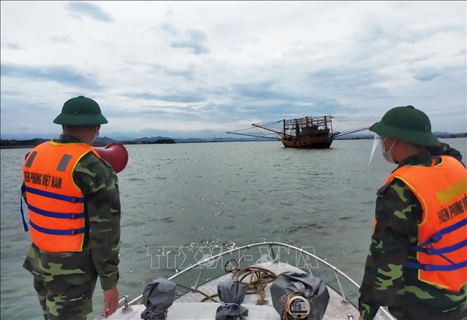 Cán bộ chiến sỹ Biên phòng Quảng Bình kêu gọi, hướng dẫn tàu, thuyền vào neo đậu tại bến thuyền, cảng cá đảm bảo an toàn. Ảnh minh họa: TTXVN phát