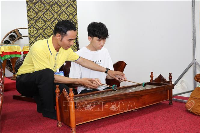 Thach Hoai Thanh (on the left), a lecturer at the School of Southern Khmer Language, Culture, and Arts and Humanities (under Tra Vinh University), is instructing students on traditional Khmer musical instrument performance.
