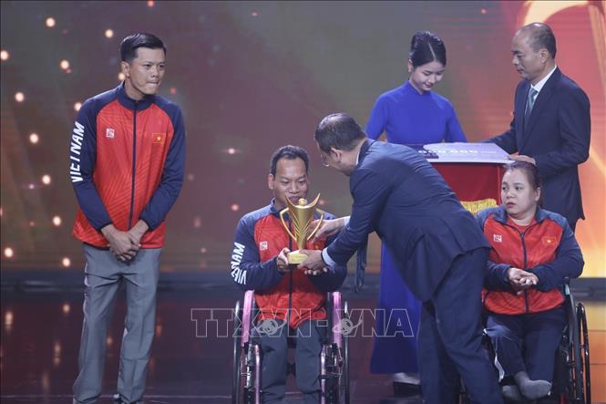 Ban tổ chức trao Cúp Chiến thắng, hạng mục VĐV người khuyết tật của năm cho VĐV cử tạ Lê Văn Công. Ảnh: Minh Quyết/TTXVN