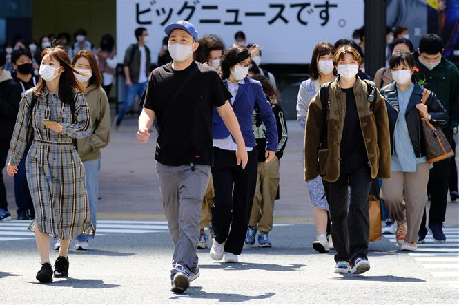 Người dân đeo khẩu trang phòng COVID-19 khi lưu thông trên đường phố tại Tokyo, Nhật Bản ngày 18/4/2021. Ảnh: AFP/TTXVN